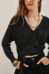 Cardigan crop negro tejido en punto desagujado con lurex, escote V cruzado y lazo de ajuste en la cintura.