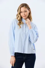 Camisa rayada de manga larga, confeccionada en algodón, con cuello mao y cierre frontal de botones.