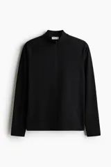 Remera deportiva negra de manga larga con cuello elevado y medio cierre frontal. Presenta mangas raglán superlargas con abertura para el pulgar.