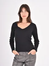 Remera de manga larga en color negro, confeccionada en tejido acanalado con escote en V y delicado detalle de puntilla en el borde.