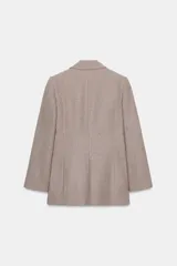 Blazer de corte sastrero confeccionado en tejido de lana con diseño de espiga. Presenta cuello con solapas, hombreras, cierre frontal con un botón y bolsillos delanteros con solapa.
