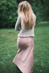 Buzo corto de punto pointelle color gris, con cuello redondo, mangas largas y terminaciones festoneadas en cuello y puños. Presenta un ribete acanalado con volados en el bajo.