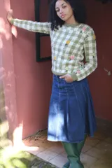 Sweater tejido en jacquard de cuadros bicolor verde y crudo, elaborado en lana merino, con delicados bordados florales hechos a mano.