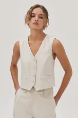 Conjunto color beige compuesto por un top sin mangas y un pantalón chino de lino metalizado, con tiro medio-alto, pierna recta, bolsillos laterales y traseros.