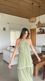 Vestido largo de gasa color verde sage, con escote halter y espalda regulable. Presenta detalles de volados fruncidos en diagonal a lo largo del diseño.