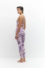 Calza deportiva de tiro alto con estampado tie-dye en tonos violeta y lila, confeccionada en tejido elástico y transpirable.