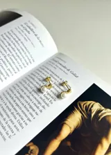 Aros colgantes con perlas y base dorada en forma de corazón.