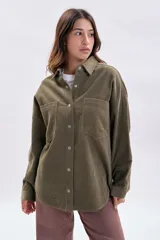 Sobrecamisa de pana color verde, con cuello clásico, cierre frontal con botones metálicos y dos bolsillos delanteros con solapa.