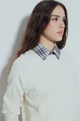 Sweater de punto color negro, con cuello redondo y diseño texturizado con ondas en relieve. Presenta mangas largas y un calce cómodo y holgado.