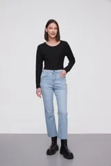 Pantalon jean de corte flare, tiro medio, con ruedo desflecado y cierre frontal con botón y cremallera.