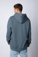 Buzo canguro oversize de tela friza, color negro, con capucha, cordones ajustables con logo y bolsillo frontal tipo canguro.