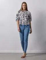 Blusa de gasa blanca con estampado de hojas en azul marino, cuello a la base con escote en V y botones, y mangas cortas abullonadas.