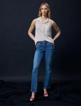 Blusa color crema sin mangas, con cuello camisero, cierre frontal con botones y bolsillo de crochet.