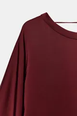 Vestido midi de Zara Woman Collection confeccionado en viscosa satinada, color bordó. Presenta cuello barco, mangas por debajo del codo y bajo recto, con detalle de lazo fino en la parte posterior del cuello.