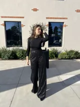 Pantalón negro con lentejuelas plateadas, de corte palazzo y cintura alta.