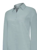 Blusa de lino orgánico color celeste de RKF, modelo Lirio, con calce regular, cuello camisero, cierre frontal con botones y un bolsillo aplicado en el pecho.