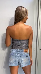 Top strapless ajustado, color plateado con efecto glitter o lentejuelas. Presenta frunces en la parte delantera y trasera.