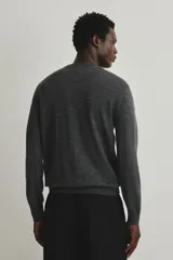 Buzo de punto fino confeccionado en lana merino, color gris oscuro. Presenta cuello redondo, mangas largas y terminaciones acanaladas en cuello, puños y bajo. Posee un corte regular fit para una silueta clásica.