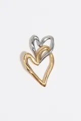 Caravanas con diseño de dos corazones entrelazados de textura irregular. Presentan un acabado bicolor en tonos dorado y plateado.