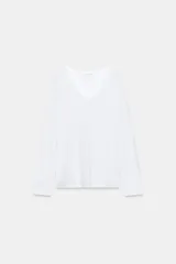 Camiseta blanca de algodón con escote en V y mangas largas, corte holgado y diseño oversize.