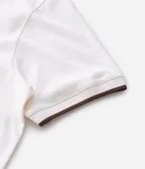 Camisa polo de manga corta confeccionada en algodón, con cuello en V y detalles en color contrastante en el cuello y los puños. Presenta un diseño de tejido en media malla, ofreciendo una textura suave y transpirable.