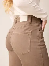 Pantalón jean de tiro alto y corte recto, color marrón chocolate, con aberturas laterales en el ruedo.