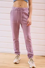 Pantalón babucha deportivo color lila, con elástico en la cintura y puños, cordones regulables y dos bolsillos laterales.