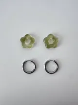 Aros de acero quirúrgico argolla con dije colgante en forma de flor de resina color gris marmoleado.