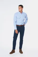 Pantalón de vestir azul marino, de corte recto, con bolsillos laterales y traseros. Se ajusta a la cintura con cinturón de cuero marrón.