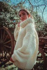 Sweater de punto grueso color blanco, con cuello tortuga y mangas semi anchas, tejido a mano en lana merino.