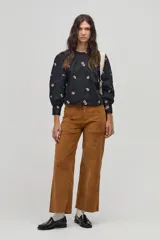 Pantalón de pana color marrón claro, de corte ancho, con bolsillos laterales y traseros.