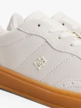 Zapatillas de corte bajo Tommy Hilfiger de inspiración retro, confeccionadas en ante color blanco con suela de goma color caramelo. Presentan monograma TH tonal en el lateral, detalles de ventilación en la puntera y cierre con cordones.