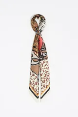 Pañuelo de poliéster reciclado con diseño estampado combinando animal print y detalles gráficos, con un charm metálico en forma de corazón.