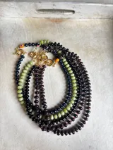 Collar de piedras naturales de calcedonia pulida en tonos verdes y granates, con detalle central de cristal de Murano y cierre tipo marinero con baño de oro 18k.