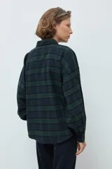 Camisa de manga larga con estampado de cuadros en tonos verde y azul marino, cuello clásico y cierre frontal con botones.