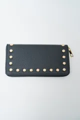 Billetera negra con cierre perimetral y tachas doradas decorativas en el borde frontal.