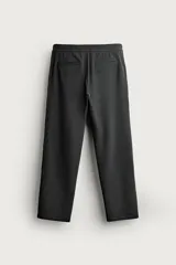 Pantalón negro confeccionado en mezcla de algodón, con cintura elástica, bolsillos frontales y cierre con cremallera y botón.