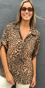 Camisa de manga corta con estampado animal print, cuello clásico y cierre frontal con botones. Presenta un corte holgado y fluido.