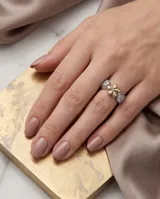 Anillo de plata 925 con aplique central en forma de flor en oro de 18k y detalles laterales con circonias engarzadas.