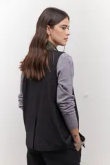 Chaleco azul con cuello en V y cierre frontal con botones marrones.