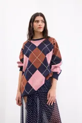 Sweater holgado de tejido de punto con patrón de rombos en tonos azul marino, rosa y marrón, con detalles de líneas en lurex. Presenta cuello redondo y mangas largas.
