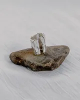 Anillo abierto de diseño rústico y orgánico, con textura irregular que evoca la naturaleza. Realizado artesanalmente en metal.