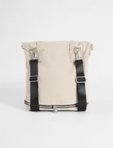 Mochila shopper color beige, confeccionada en poliéster. Presenta un diseño versátil con múltiples cierres, compartimento inferior expandible y un bolsillo frontal removible que funciona como estuche. Incluye correas ajustables y removibles para usar como mochila o bandolera, además de asas fijas para llevar al hombro.