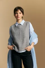 Chaleco tejido de punto en color azul marino, con diseño de textura sutil en relieve, escote redondo y terminaciones acanaladas en cuello, sisas y ruedo.