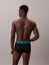 Pack de tres bóxers tipo trunk de Calvin Klein, color negro. La cinturilla elástica distintiva presenta el logo de la marca en tres colores: azul cian, blanco y blanco.