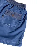 Short de baño azul de microfibra lisa, con cintura elastizada y cordón ajustable. Tiene dos bolsillos laterales y uno trasero.
