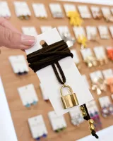 Choker con tiento de gamuza sintética color marrón oscuro y dije de candado dorado.