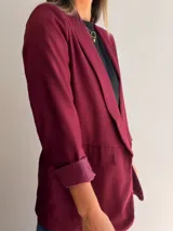 Blazer sastrero de corte clásico con solapas frontales y bolsillos con solapa. Presenta mangas largas con puños vueltos y un diseño forrado que ofrece una caída estructurada y elegante.