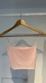 Top rosado con breteles elásticos y textil elastizado con leve brillo.