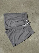 Short de baño gris con estampado geométrico, cintura elástica y cordón de ajuste blanco.